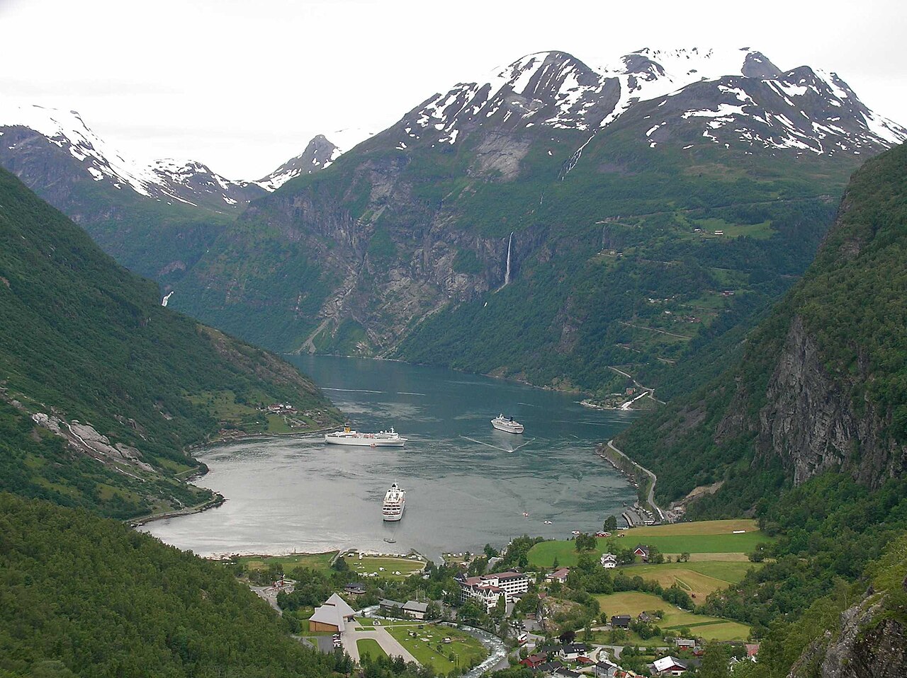 Montanhas, barcos e a vila de Geiranger junto ao Geirangerfjord, na Noruega
